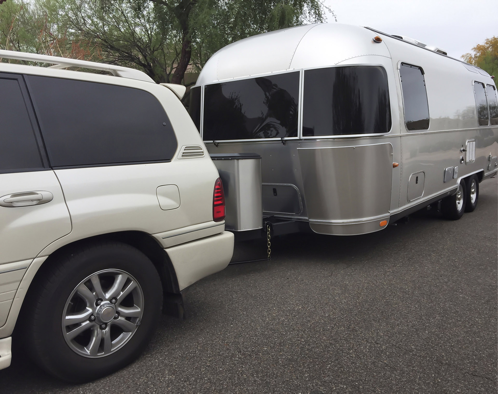 Large white SUV vehicle towing a camping trailer